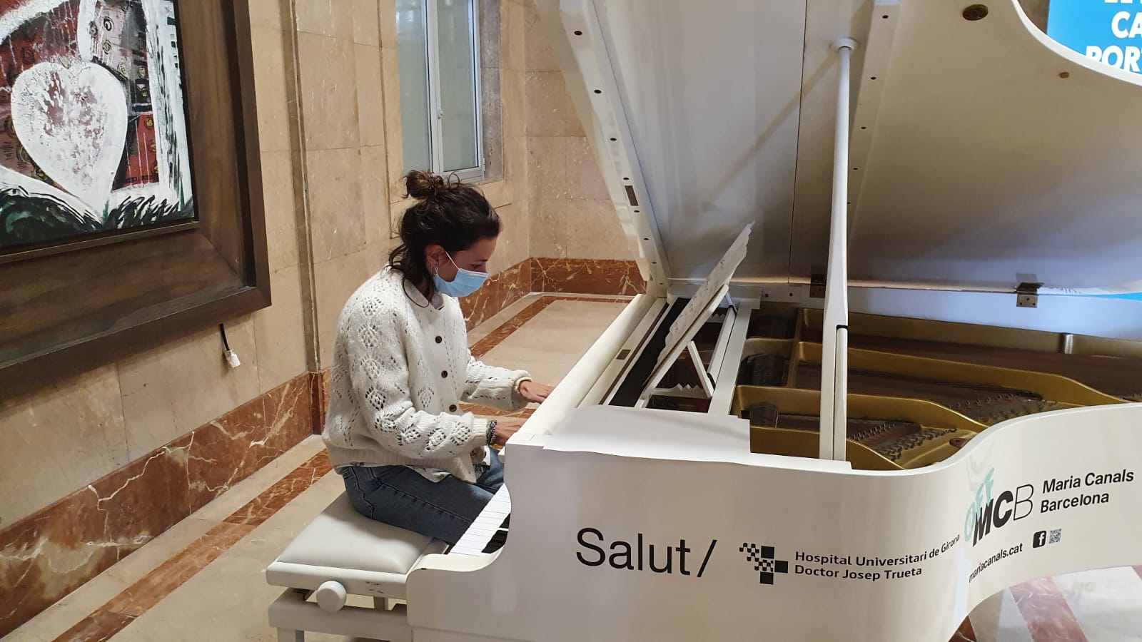 Una professional de l'Hospital Trueta toca el piano que es troba instal·lat al vestíbul del centre