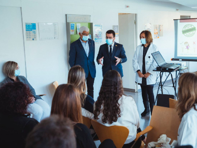 El president i el conseller conversant amb les i els professionals del CAP