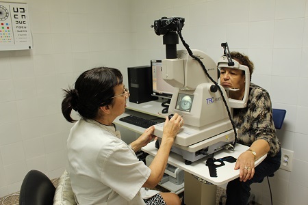 Foto d'una professional realitzant una retinografia