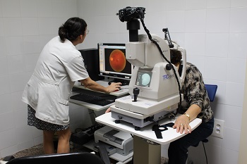 Foto nº2 d'una Professional realitzant una retinografia a una pacient.