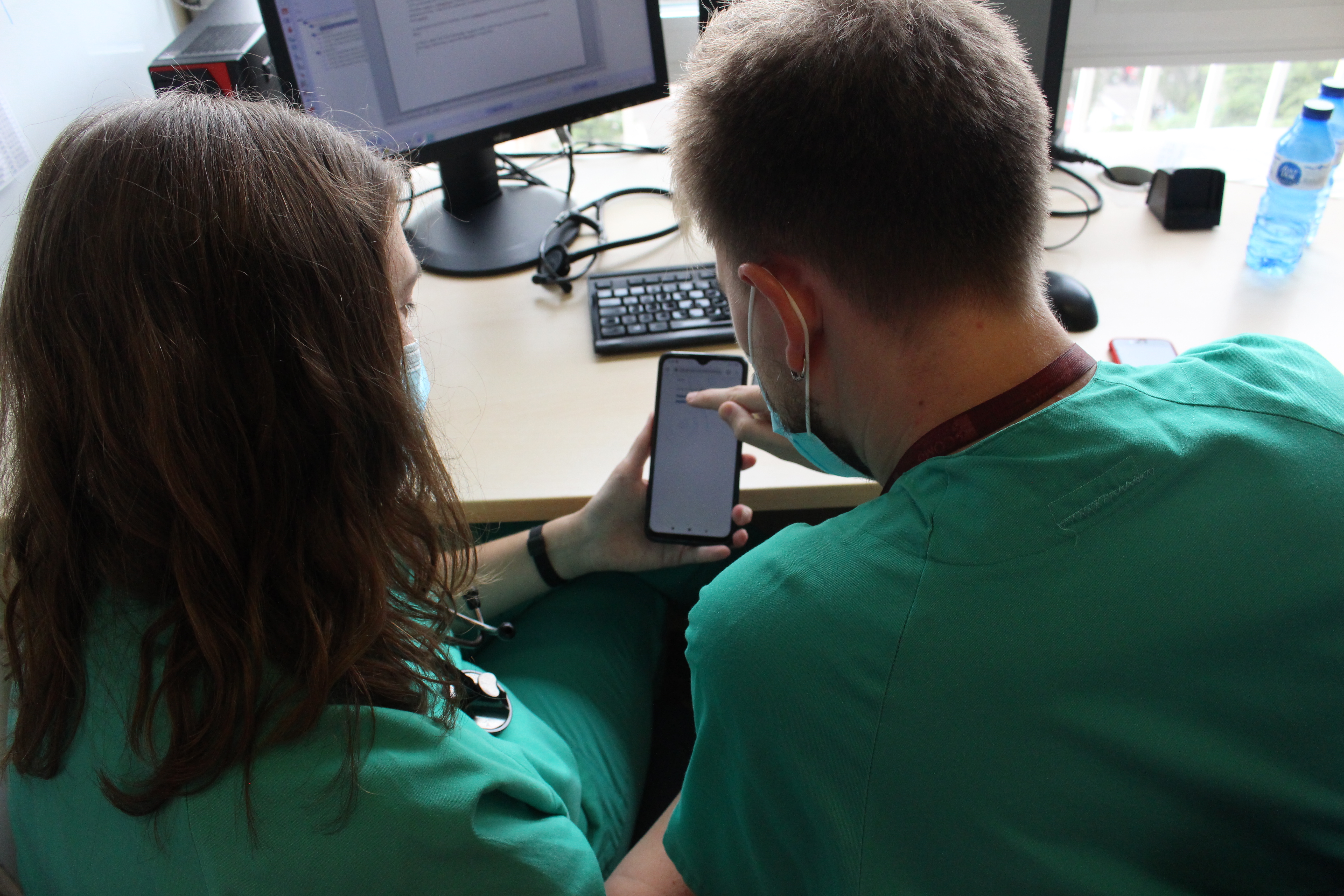 Dos cardiòlegs observen dades que reben al seu terminal mòbil