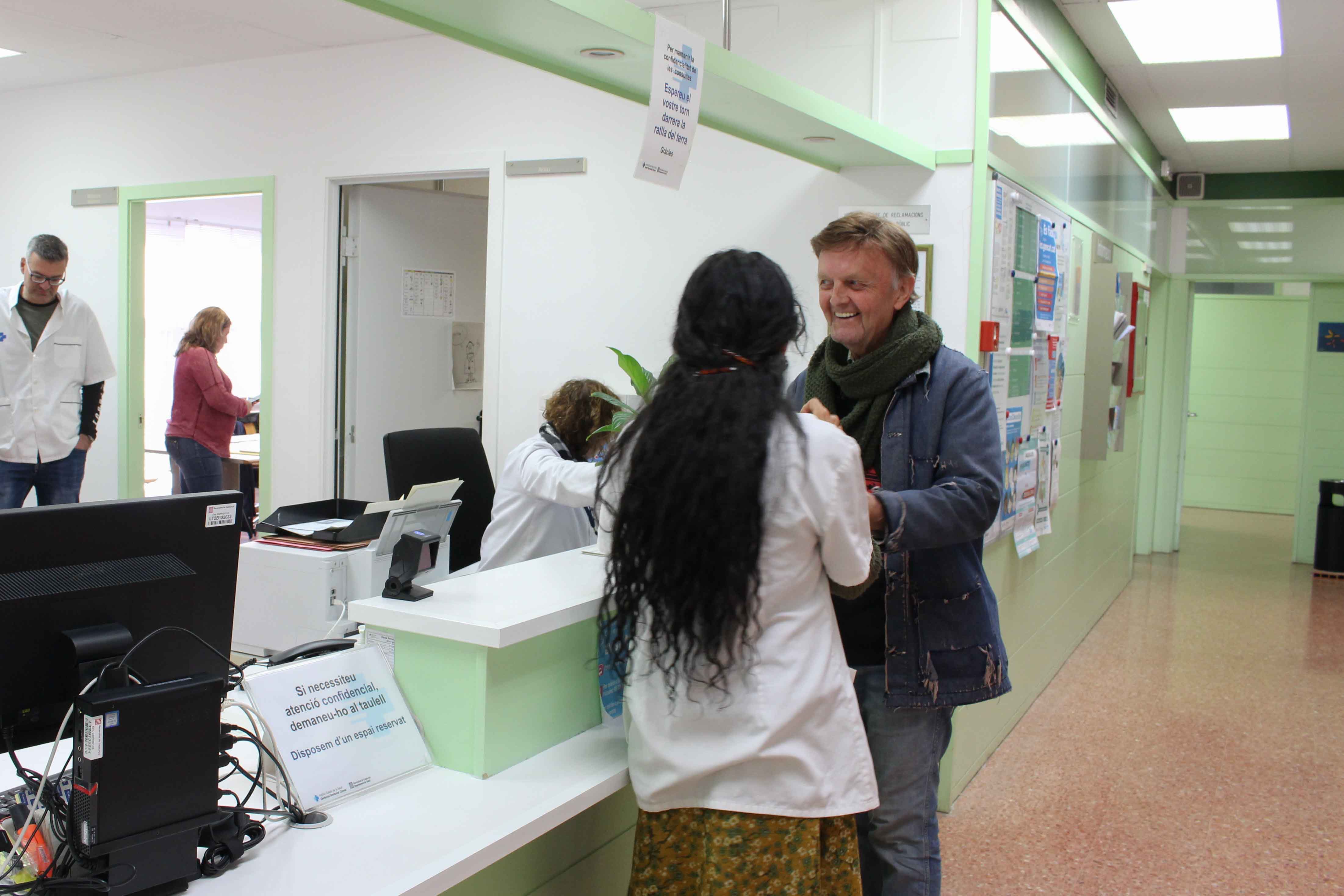 Pacient i metge conversant a recepció