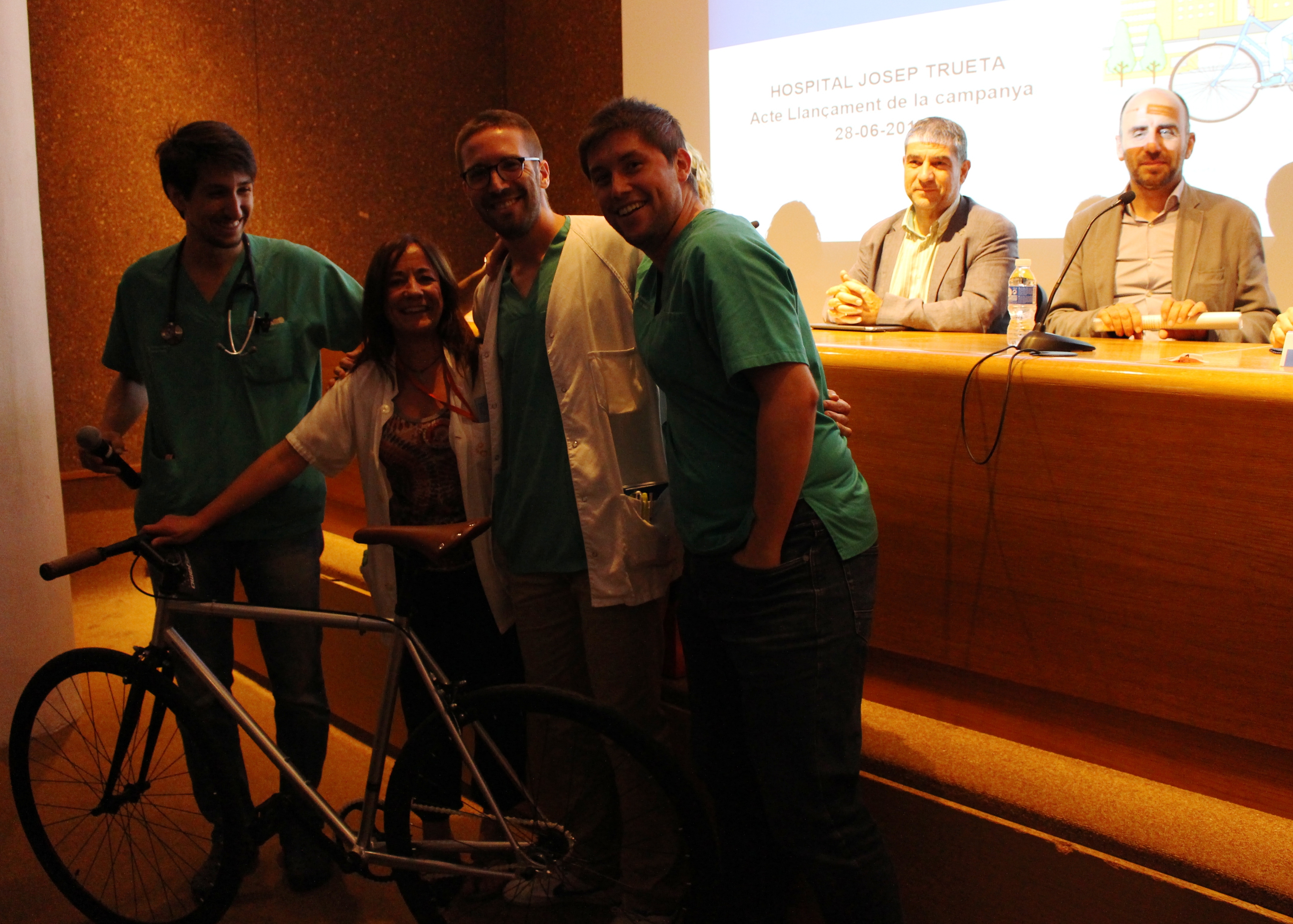 Foto de professionals del Servei de Cardiologia amb la bicicleta que han sortejat als assistents de la presentació de la campanya #ElTruetaPedala
