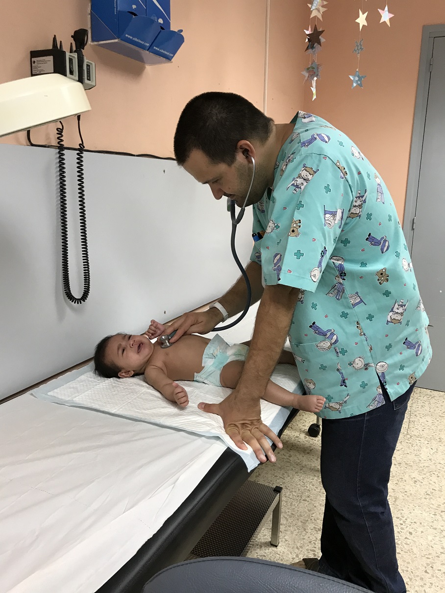 Fotografia d'un professional del Servei de Pediatria atenent visita.