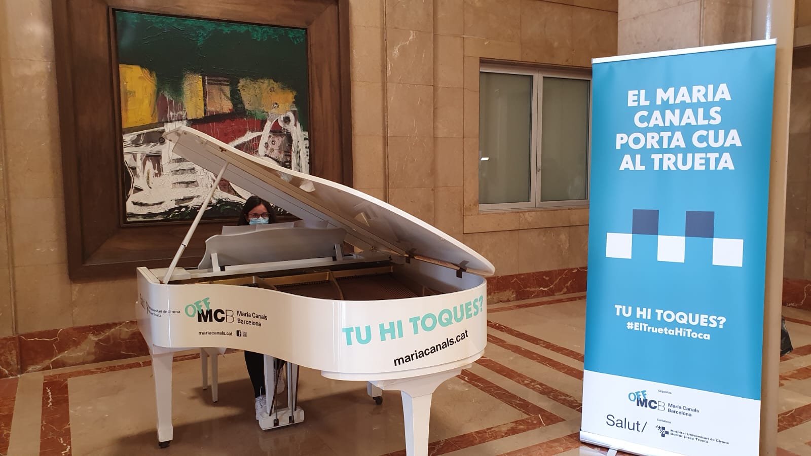 Una professional de l'Hospital Trueta toca el piano que es troba instal·lat al vestíbul del centre