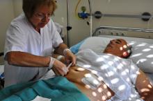 Una professional d'infermeria fa cures a un pacient ingressat a la UPIC