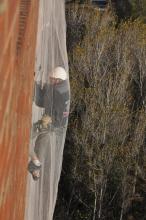 un operari realitzant tasques de manteniment a la façana de l'hospital Trueta