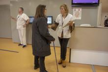 Professional d'infermeria parlant explicant la campanya de sensibilització sobre la prevenció de les caigudes a una usuaria.