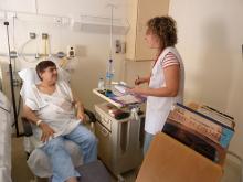 Voluntària de Biblioarreu ofereix llibres a una pacient ingressada al Trueta