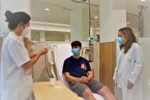 pacient jove a l'hospital de dia de l'Hospital Santa Caterina, amb dos professionals sanitaris que li fan una prova d'al·lèrgia