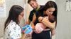 Una parella acaronant la seva filla després de ser immunitzada contra el VRS