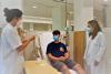 pacient jove a l'hospital de dia de l'Hospital Santa Caterina, amb dos professionals sanitaris que li fan una prova d'al·lèrgia